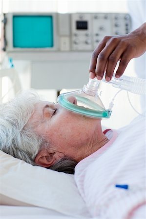 A doctor putting oxygen mask on a patient in a hospital Stock Photo - Budget Royalty-Free & Subscription, Code: 400-04201395