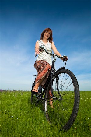 simsearch:400-03934248,k - Happy young woman on a green meadow with a vintage bicycle Stock Photo - Budget Royalty-Free & Subscription, Code: 400-04201794
