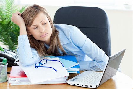 simsearch:400-05729275,k - Stressed young businesswoman sitting at her desk in the office Stock Photo - Budget Royalty-Free & Subscription, Code: 400-04201870