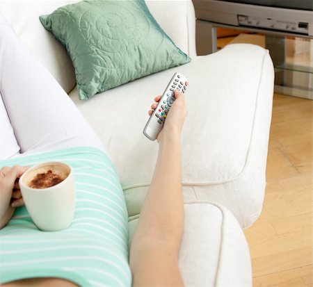 simsearch:400-04210845,k - Close-up of a woman drinking a coffee while watching TV lying on a sofa Stock Photo - Budget Royalty-Free & Subscription, Code: 400-04202268