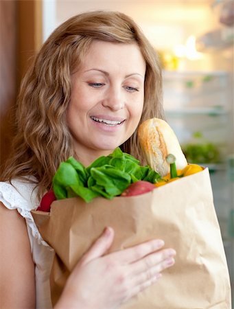 simsearch:400-04605857,k - Charming woman holding a grocery bag in the kitchen Stock Photo - Budget Royalty-Free & Subscription, Code: 400-04202333