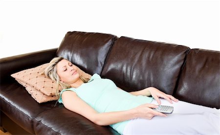 simsearch:400-04210845,k - Laid-backwoman lies on brown sofa and watches TV Stock Photo - Budget Royalty-Free & Subscription, Code: 400-04203607