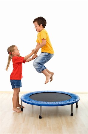 Kids having fun on a trampoline in the gym - helping each other - isolated Stock Photo - Budget Royalty-Free & Subscription, Code: 400-04214573