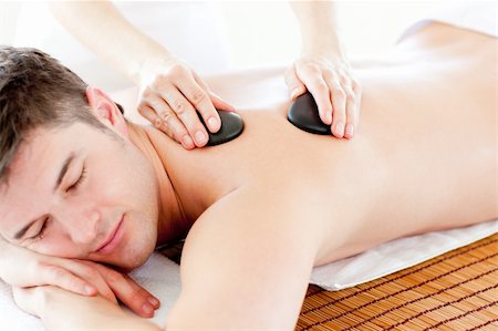 simsearch:400-04192083,k - Positive young man enjoying a back massage with hot stone in a healt spa Stock Photo - Budget Royalty-Free & Subscription, Code: 400-04210866