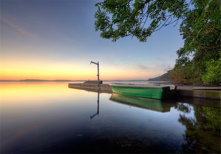 simsearch:400-04756224,k - sunrise at a pier with a boat and branch hanging out over the water Stock Photo - Budget Royalty-Free & Subscription, Code: 400-04211696
