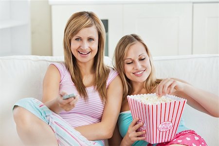 simsearch:400-04210845,k - Relaxed female friends eating popcorn watching tv at home Stock Photo - Budget Royalty-Free & Subscription, Code: 400-04212415