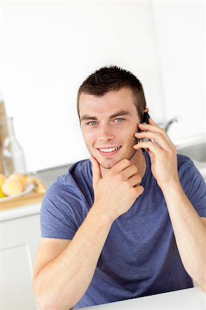 simsearch:400-04212823,k - Handsome young man talkng on phone and smiling at the camera at home Stock Photo - Budget Royalty-Free & Subscription, Code: 400-04212822