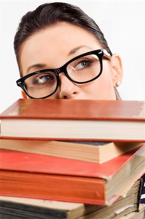 simsearch:400-04860880,k - pretty student with big glasses playing and hiding her face behind a pile of book and looking om one side Stock Photo - Budget Royalty-Free & Subscription, Code: 400-04213413