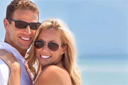 simsearch:6109-06004195,k - A sexy and attractive man and woman couple smiling and happy wearing sunglasses in sunshine at the beach Stock Photo - Budget Royalty-Free & Subscription, Code: 400-04226828