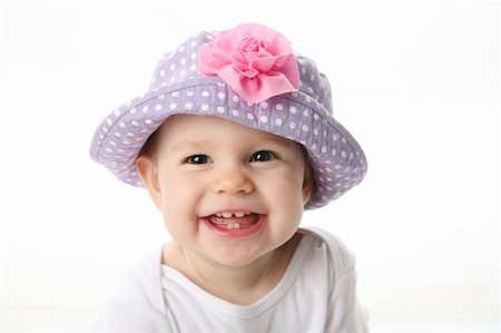 simsearch:400-05153083,k - Smiling baby girl showing teeth wearing a purple polka dot hat with pink flower isolated on white background Stock Photo - Budget Royalty-Free & Subscription, Code: 400-04227524