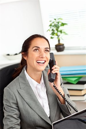 simsearch:400-04212823,k - Cheerful hispanic businesswoman talking on phone in front of her laptop in her office sitting at her desk Stock Photo - Budget Royalty-Free & Subscription, Code: 400-04220794