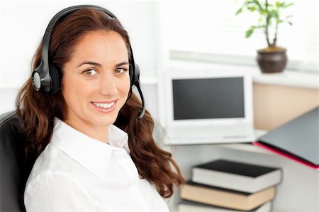 simsearch:400-05287143,k - Delighted hispanic businesswoman with headset sitting at her desk in a call center Stock Photo - Budget Royalty-Free & Subscription, Code: 400-04220851