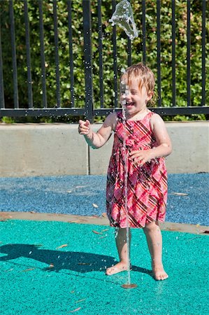 Cute little European toddler girl having fun with water at the playground in park Stock Photo - Budget Royalty-Free & Subscription, Code: 400-04221761