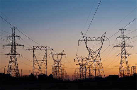 A long line of electrical transmission towers carrying high voltage lines. Stock Photo - Budget Royalty-Free & Subscription, Code: 400-04234577