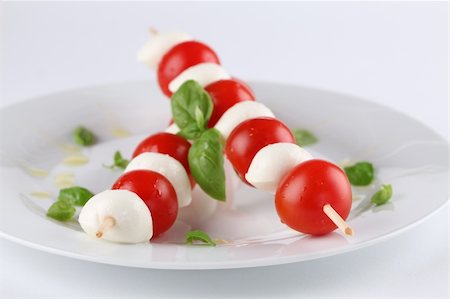 simsearch:700-01099893,k - Cherry tomatoes and mozzarella on skewers, garnished with basil leaves and olive oil Stock Photo - Budget Royalty-Free & Subscription, Code: 400-04232385