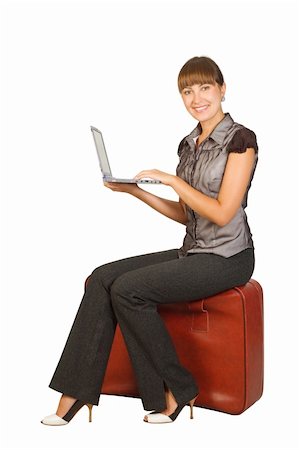 Attractive businesswoman sitting on suitcase with laptop on her hands Stock Photo - Budget Royalty-Free & Subscription, Code: 400-04243141