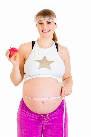 simsearch:400-04798379,k - Smiling beautiful pregnant woman measuring her belly and holding apple isolated on white Stock Photo - Budget Royalty-Free & Subscription, Code: 400-04243265