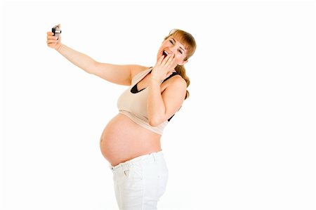 simsearch:400-04817039,k - Laughing pregnant woman photographing herself isolated on white Stock Photo - Budget Royalty-Free & Subscription, Code: 400-04243284