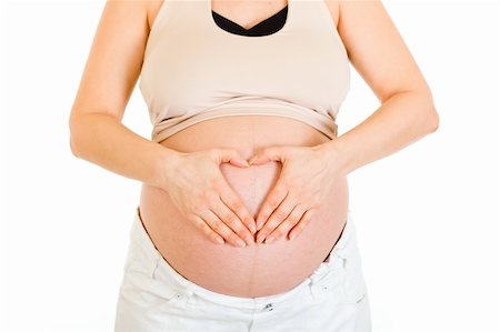 simsearch:400-04798379,k - Pregnant woman making heart with her hands on belly isolated on white.  Close-up. Stock Photo - Budget Royalty-Free & Subscription, Code: 400-04243280