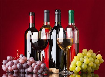 simsearch:400-04226436,k - Several bottles of white and red wine, two glasses and grapes on a red background Stock Photo - Budget Royalty-Free & Subscription, Code: 400-04257243