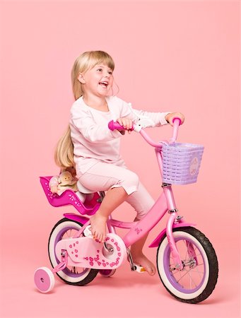 riding bike female basket - Young girl on her bike towards pink background Stock Photo - Budget Royalty-Free & Subscription, Code: 400-04257296