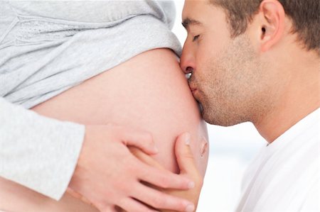 pregnant women kissing - Close up of a man kissing the belly of his lovely pregnant wife standing in the bedroom Stock Photo - Budget Royalty-Free & Subscription, Code: 400-04267461