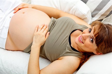 simsearch:400-04875116,k - Smiling beautiful pregnant woman relaxing on couch at home and  holding her belly Stock Photo - Budget Royalty-Free & Subscription, Code: 400-04268430