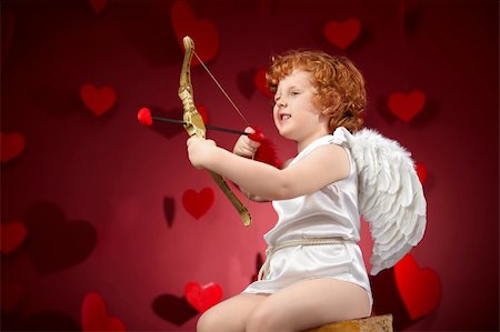 Little boy in an image of the cupid on a red background Stock Photo - Budget Royalty-Free & Subscription, Code: 400-04262977