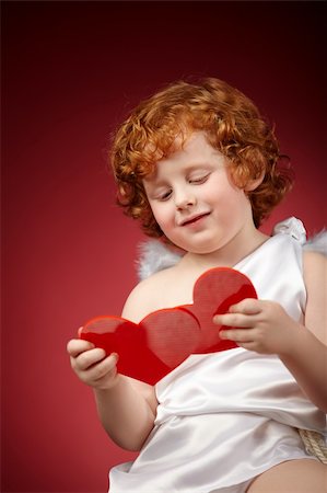 Little boy with wings behind the back holds two hearts Stock Photo - Budget Royalty-Free & Subscription, Code: 400-04262980