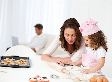 sugar mama - Mother and daughter cooking while dad relaxing on the sofa Stock Photo - Budget Royalty-Free & Subscription, Code: 400-04287006