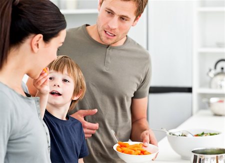 simsearch:400-05744780,k - Little boy giving his mother a carrot while preparing lunch in the kitchen Stock Photo - Budget Royalty-Free & Subscription, Code: 400-04287054