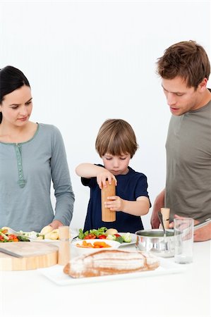 simsearch:400-05744780,k - Cute boy putting salt and pepper in his salad in the kitchen with his parents Stock Photo - Budget Royalty-Free & Subscription, Code: 400-04287055