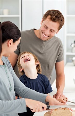 simsearch:400-05744780,k - Little boy laughing while his mother cutting bread in the kitchen Stock Photo - Budget Royalty-Free & Subscription, Code: 400-04287059