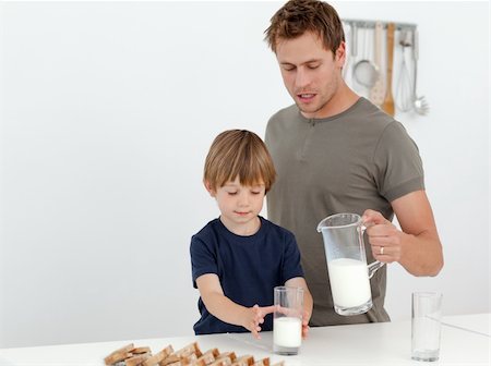 Handsome man giving milk to his son standing in the kitchen Stock Photo - Budget Royalty-Free & Subscription, Code: 400-04287060