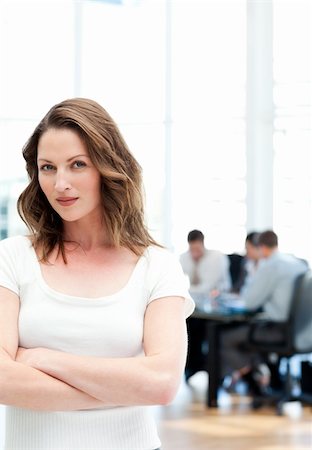 simsearch:400-05746962,k - Confident woman standing at a meeting while her team working in the background Stock Photo - Budget Royalty-Free & Subscription, Code: 400-04287080