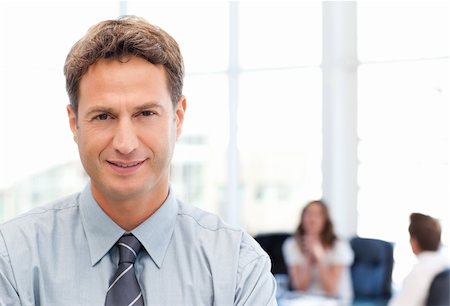 simsearch:400-05746962,k - Relaxed businessman posing in front of his team while working in the background Stock Photo - Budget Royalty-Free & Subscription, Code: 400-04287202