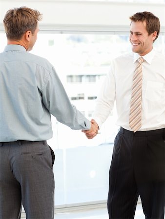 simsearch:400-04333648,k - Two happy businessmen concluding a deal by shaking their hands standing in the office Stock Photo - Budget Royalty-Free & Subscription, Code: 400-04287221