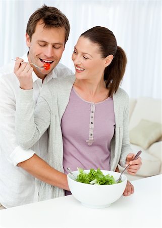 simsearch:400-05744780,k - Pretty woman giving a tomato to her boyfriend while preparing a salad in the kitchen Stock Photo - Budget Royalty-Free & Subscription, Code: 400-04287245