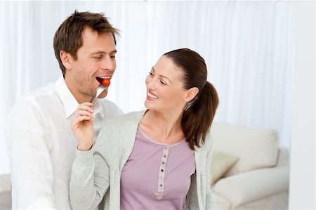 simsearch:400-05744780,k - Happy man tasting a tomato while his girlfriend preparing lunch in the kitchen Stock Photo - Budget Royalty-Free & Subscription, Code: 400-04287246
