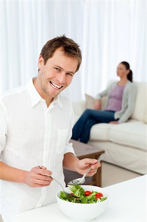 simsearch:400-05744780,k - Happy man preparing lunch while his girlfriend relaxing on the sofa Stock Photo - Budget Royalty-Free & Subscription, Code: 400-04287249
