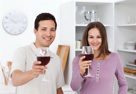 food specialist - Young couple giving a toast with glasses of red wine in the kitchen Stock Photo - Budget Royalty-Free & Subscription, Code: 400-04287289