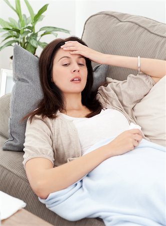 feeble - Sick woman lying on the sofa and touching her forehead to feel the temperature Stock Photo - Budget Royalty-Free & Subscription, Code: 400-04287314