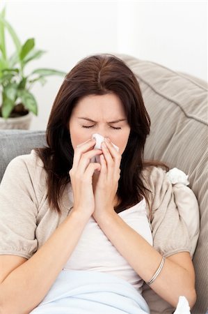 feeble - Portrait of a sick woman blowing her nose on the sofa at home Stock Photo - Budget Royalty-Free & Subscription, Code: 400-04287316