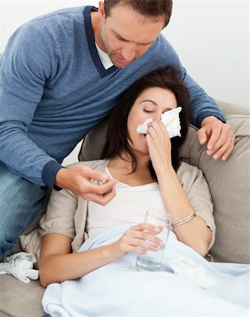 feeble - Handsome man taking care of his sick girlfriend lying on the sofa Stock Photo - Budget Royalty-Free & Subscription, Code: 400-04287322
