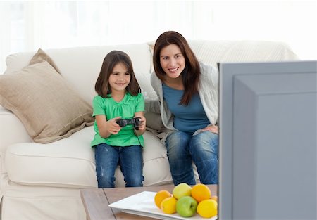 Mom and daughter playing video games together in the living room Stock Photo - Budget Royalty-Free & Subscription, Code: 400-04287351