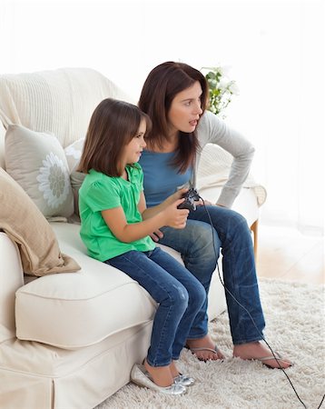 Concentrated mom and daughter playing video games together in the living room Stock Photo - Budget Royalty-Free & Subscription, Code: 400-04287353