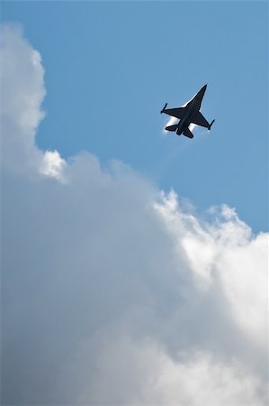 military fighter jet performing practice aerial maneuvers in a cloudy blue sky Stock Photo - Budget Royalty-Free & Subscription, Code: 400-04288053