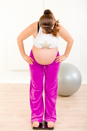 simsearch:400-05716366,k - Pregnant woman standing on weight scale at living room Stock Photo - Budget Royalty-Free & Subscription, Code: 400-04282580