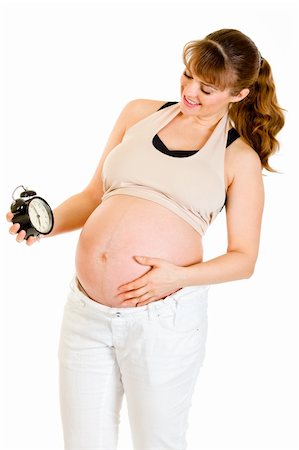 simsearch:400-04817039,k - Baby on way! Smiling pregnant woman looking at alarm clock isolated on white Stock Photo - Budget Royalty-Free & Subscription, Code: 400-04294371