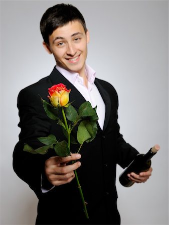 simsearch:400-04739802,k - Handsome romantic young man holding rose flower and vine bottle  prepared for a date. gray background Stock Photo - Budget Royalty-Free & Subscription, Code: 400-04296022